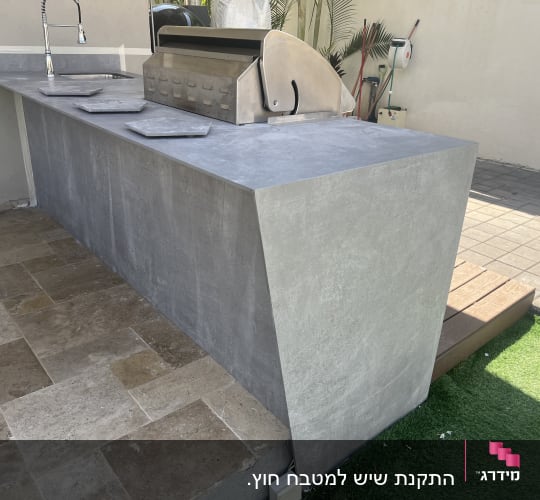 משטח עבודה חיצוני מאבן עם כיור וברז